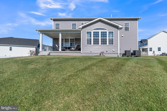 rear view of property with a patio and a lawn