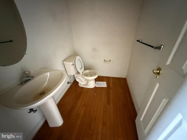 bathroom with hardwood / wood-style flooring and toilet