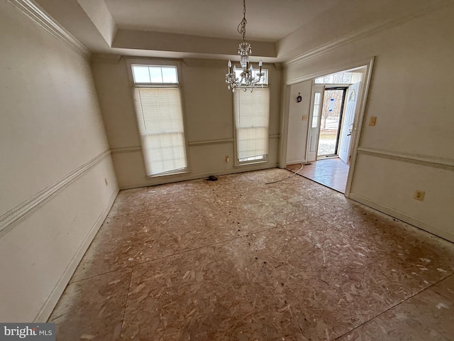 unfurnished dining area with an inviting chandelier and a raised ceiling