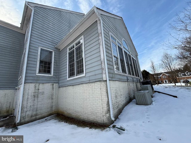 view of snowy exterior with cooling unit