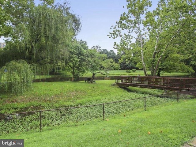 view of home's community with a yard and fence