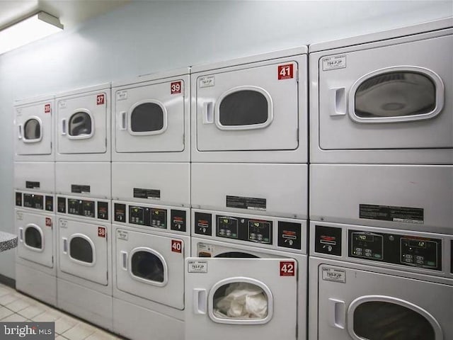 shared laundry area featuring light tile patterned floors, washing machine and dryer, and stacked washer and clothes dryer