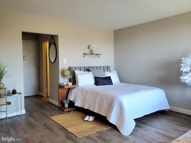 bedroom with baseboards and wood finished floors