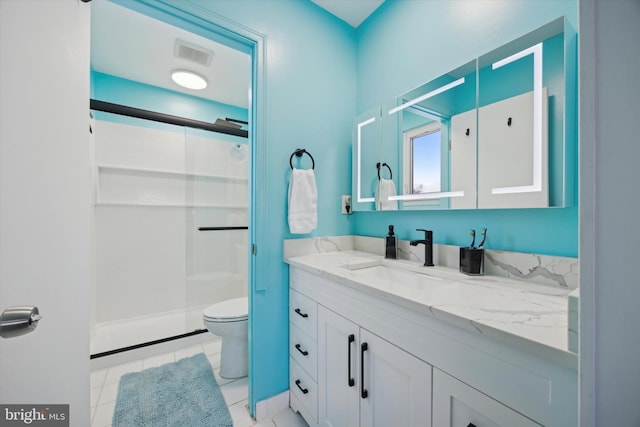 bathroom featuring tile patterned floors, vanity, toilet, and a shower with shower door