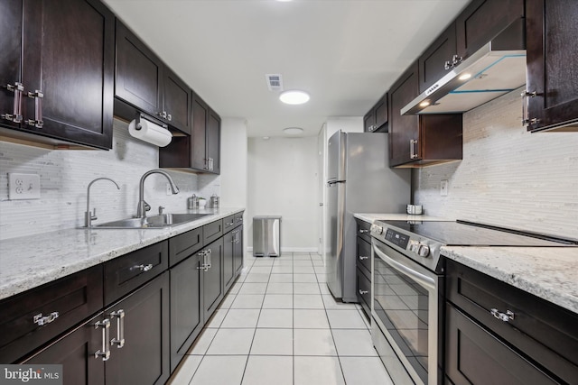 kitchen with appliances with stainless steel finishes, sink, backsplash, light tile patterned floors, and light stone countertops