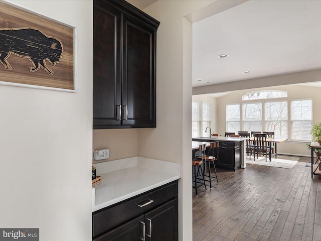 bar with sink and dark wood-type flooring