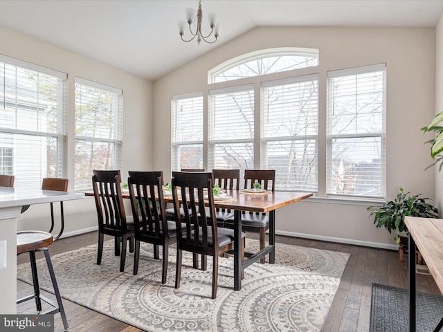 dining area with lofted ceiling, a notable chandelier, a wealth of natural light, and dark hardwood / wood-style flooring