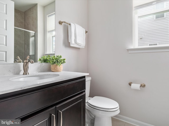 bathroom with tile patterned floors, toilet, a shower with door, and vanity