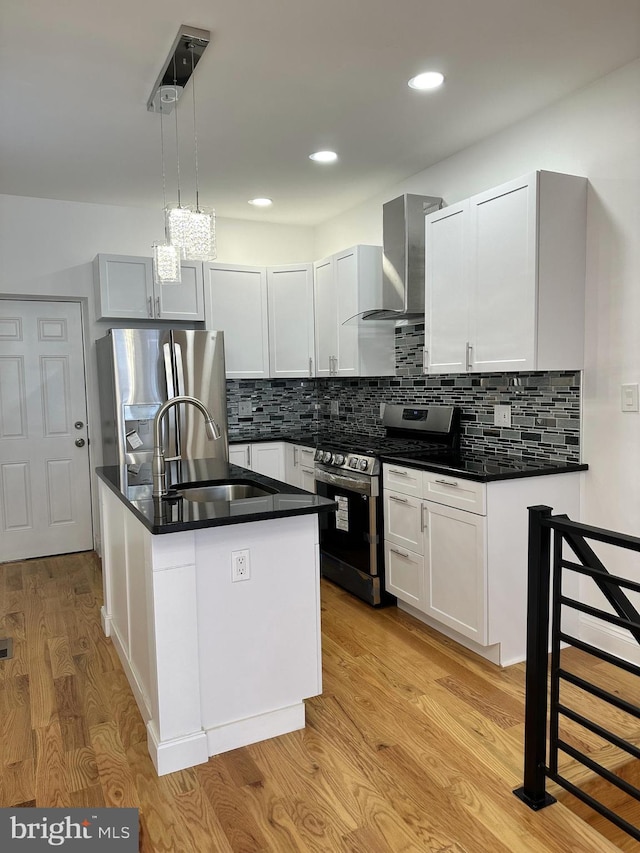 kitchen with white cabinets, wall chimney exhaust hood, and appliances with stainless steel finishes