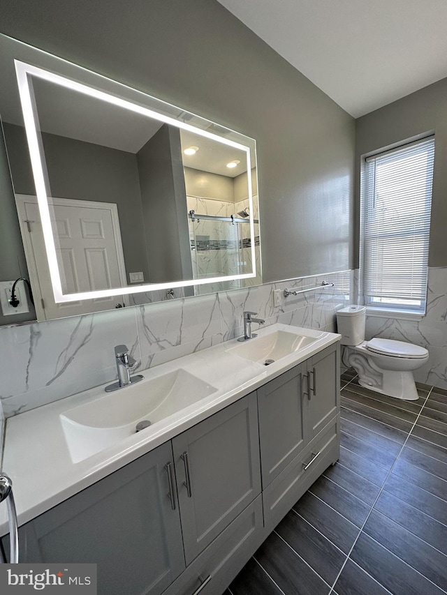 bathroom featuring tile walls, tile patterned flooring, vanity, toilet, and a shower with door