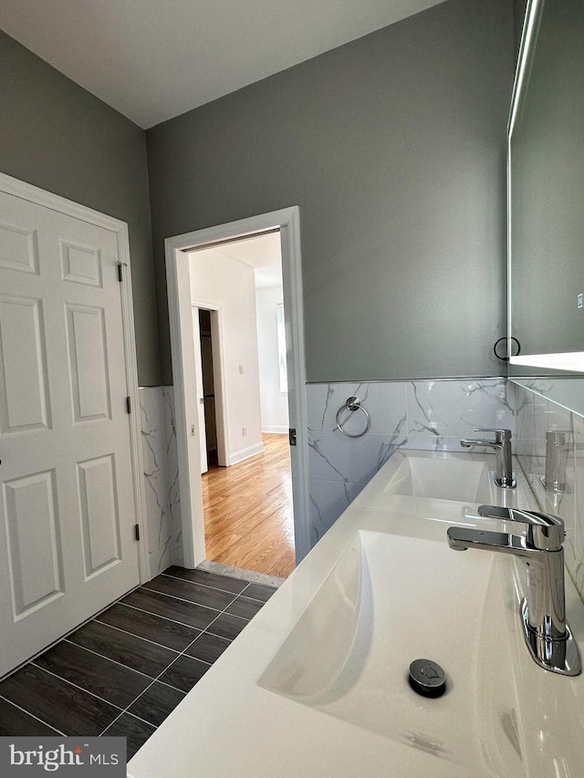 bathroom featuring vanity, hardwood / wood-style floors, and tile walls