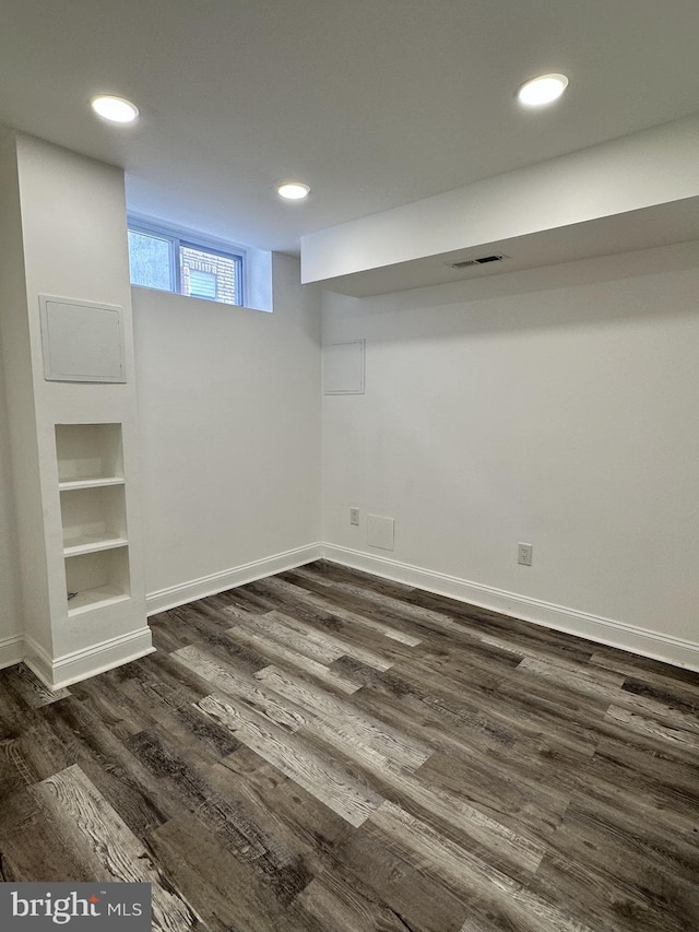 basement with dark hardwood / wood-style floors and built in features