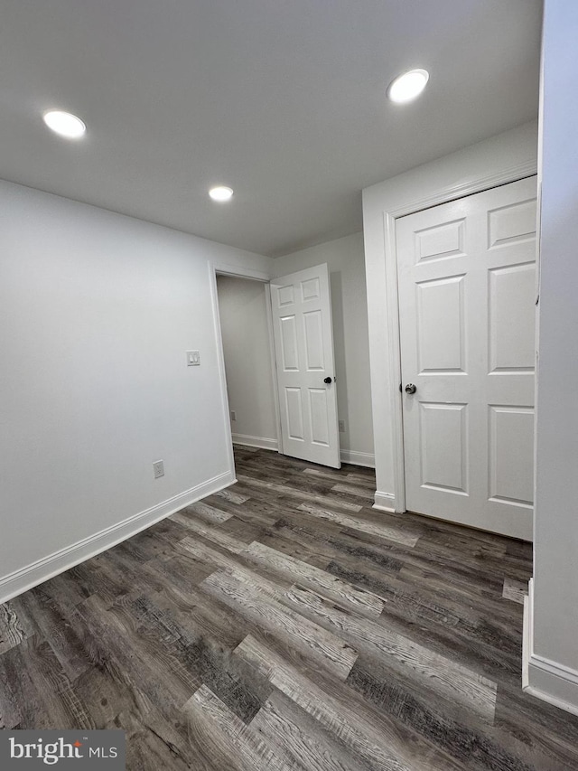 unfurnished room with dark wood-type flooring