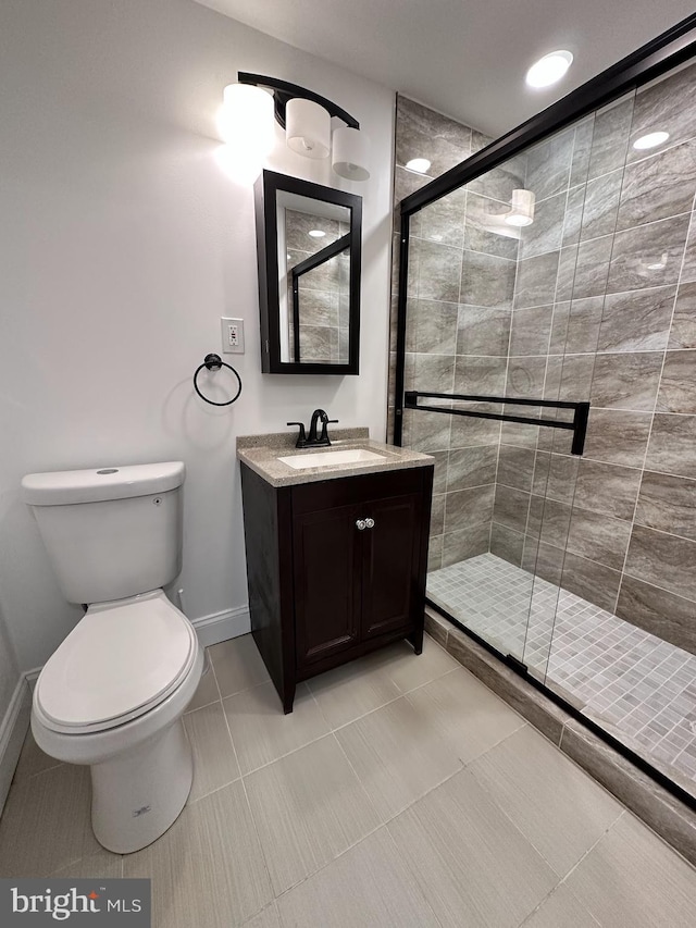 bathroom with vanity, toilet, tile patterned floors, and a shower with shower door