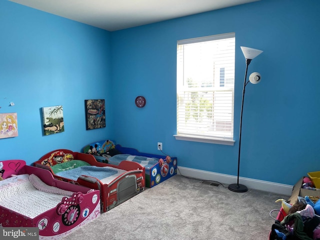 bedroom with carpet floors and multiple windows