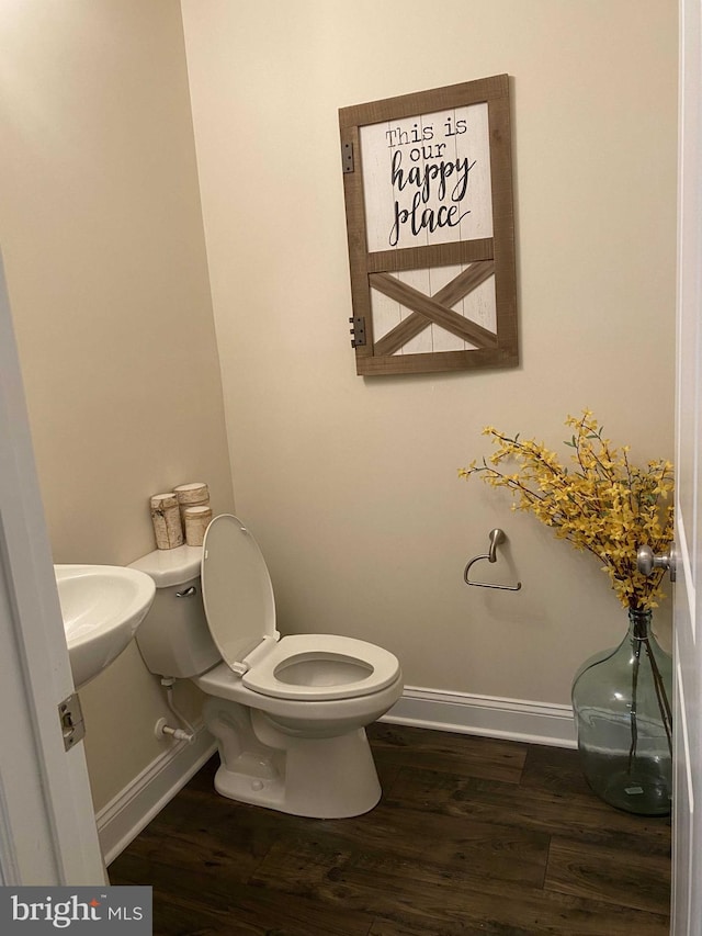 bathroom with hardwood / wood-style flooring, sink, and toilet