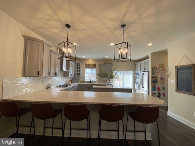 kitchen with stainless steel appliances, tasteful backsplash, hanging light fixtures, and gray cabinets