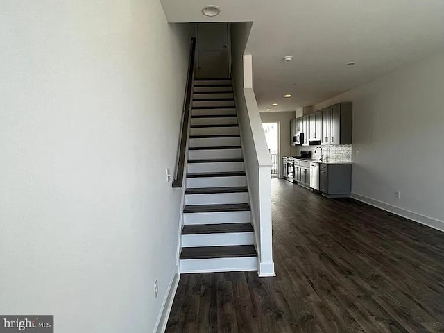 stairs with hardwood / wood-style flooring and sink