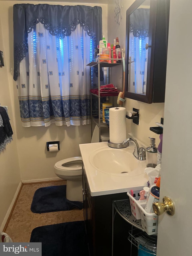 bathroom with tile patterned flooring, vanity, and toilet