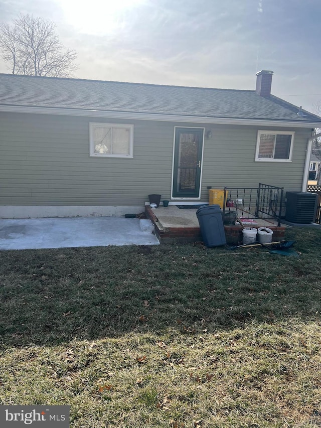 rear view of house with a yard, central AC unit, and a patio