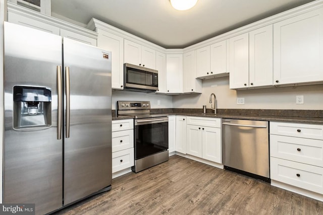 kitchen featuring sink, dark hardwood / wood-style floors, white cabinets, and appliances with stainless steel finishes