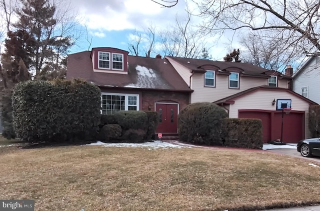 view of front property featuring a garage and a front lawn