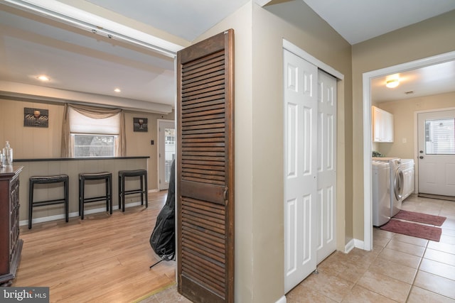 hallway featuring washing machine and clothes dryer and light hardwood / wood-style floors