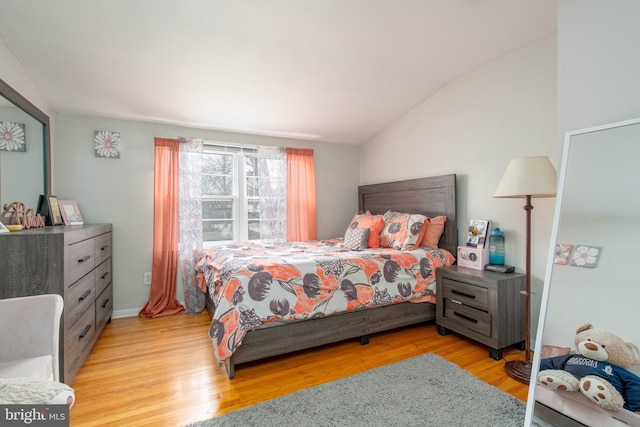 bedroom with light hardwood / wood-style flooring and vaulted ceiling