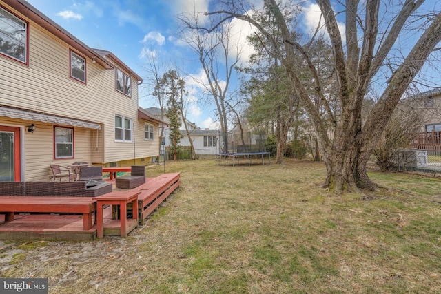 view of yard with a trampoline and a deck