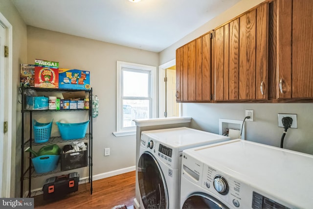 laundry room featuring cabinets, independent washer and dryer, and dark hardwood / wood-style flooring