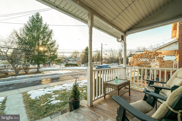 snow covered deck with a porch