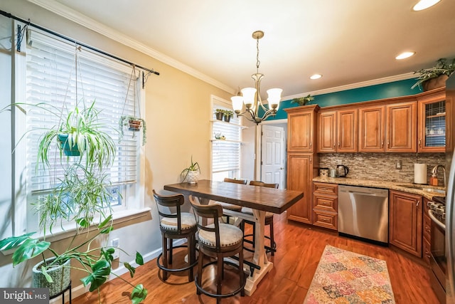 kitchen with dark hardwood / wood-style floors, tasteful backsplash, ornamental molding, light stone counters, and stainless steel appliances