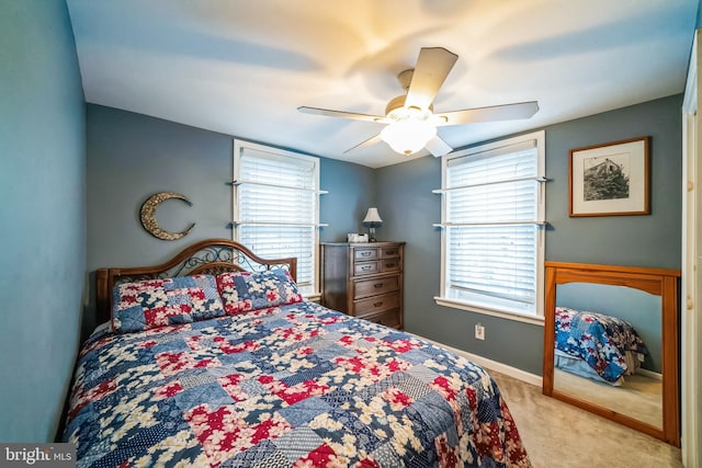 carpeted bedroom featuring ceiling fan and multiple windows