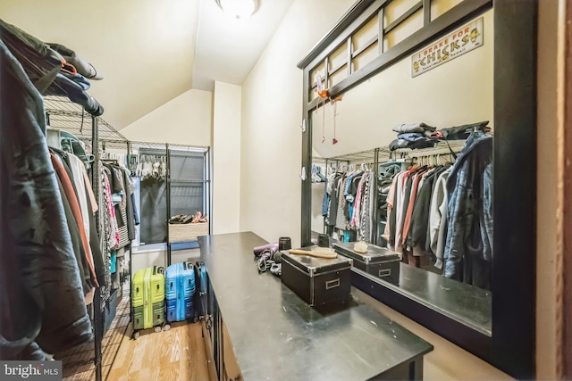 walk in closet with vaulted ceiling and light hardwood / wood-style flooring