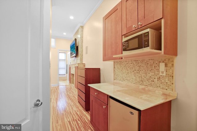 kitchen with ornamental molding, light hardwood / wood-style floors, and decorative backsplash