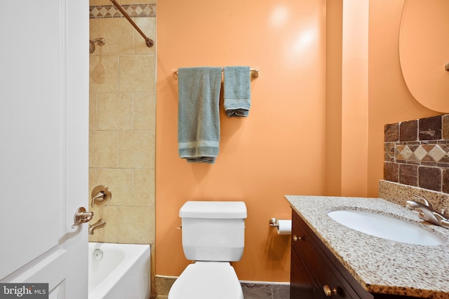 full bathroom with vanity, tiled shower / bath, and toilet