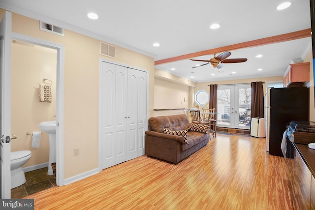 living room with ornamental molding, ceiling fan, light wood-type flooring, and french doors