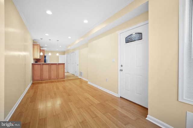 interior space with ornamental molding and light hardwood / wood-style floors