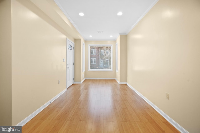 hallway featuring crown molding and light hardwood / wood-style floors