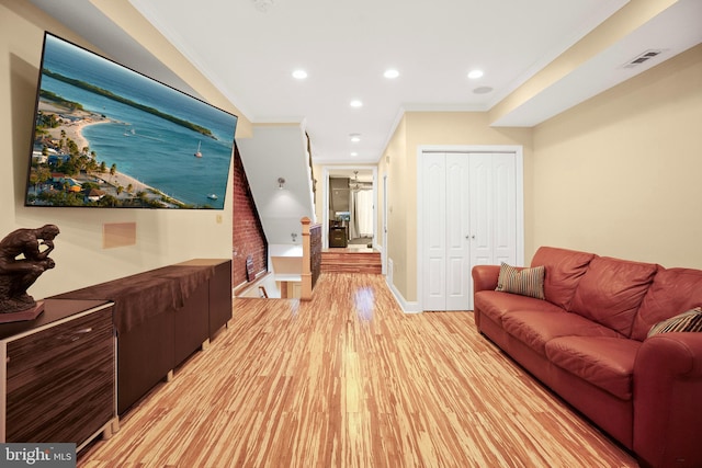 living room with ornamental molding and light wood-type flooring