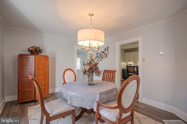 dining room featuring a notable chandelier, crown molding, and dark hardwood / wood-style floors