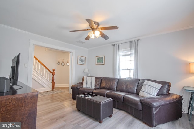 living room with crown molding, ceiling fan, and light hardwood / wood-style floors