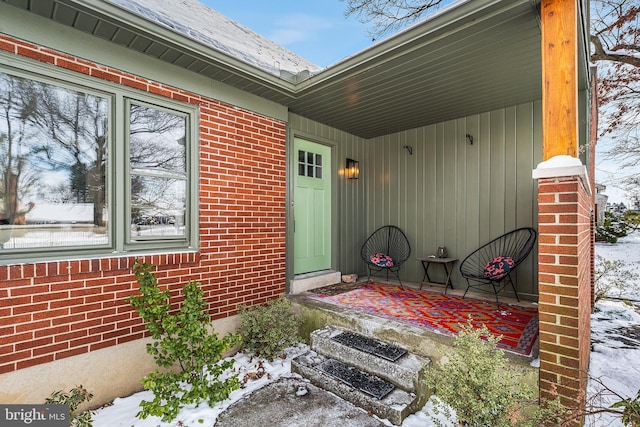 snow covered patio featuring covered porch