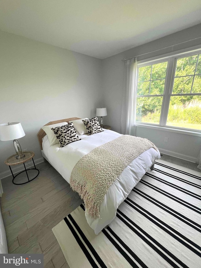 bedroom with dark hardwood / wood-style flooring