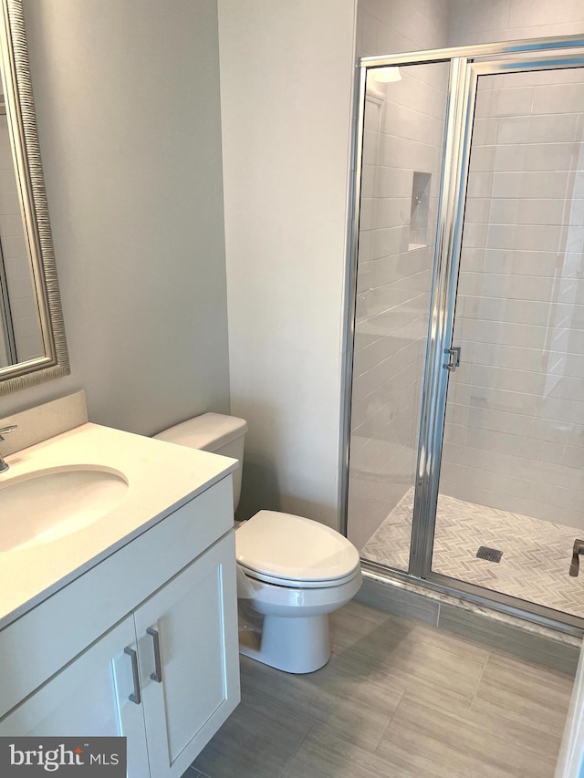 bathroom featuring vanity, toilet, and an enclosed shower