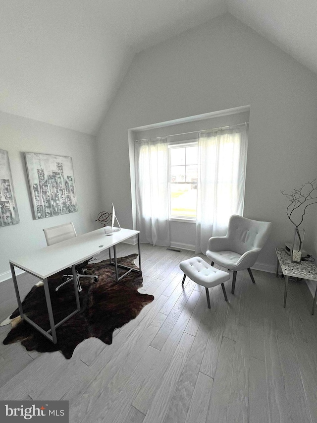 home office featuring vaulted ceiling and light hardwood / wood-style floors