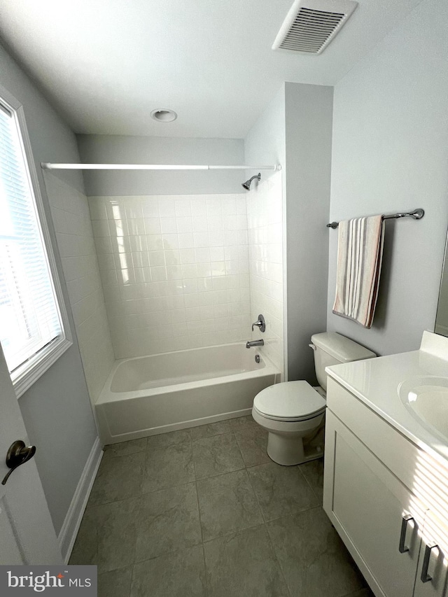 full bathroom with vanity, tiled shower / bath, tile patterned floors, and toilet