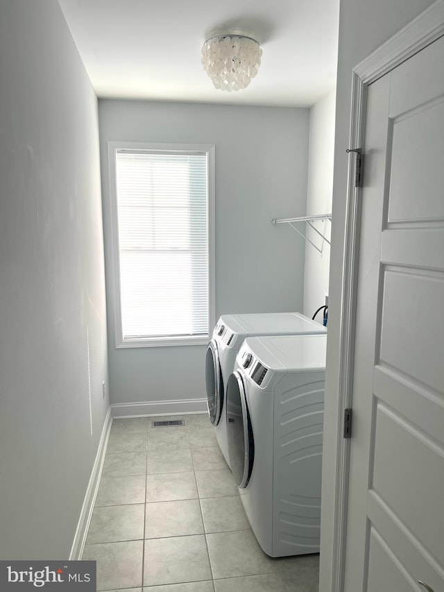 laundry area featuring light tile patterned flooring and washing machine and dryer