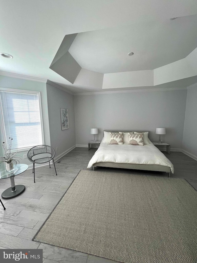 bedroom with crown molding, a raised ceiling, and light hardwood / wood-style floors