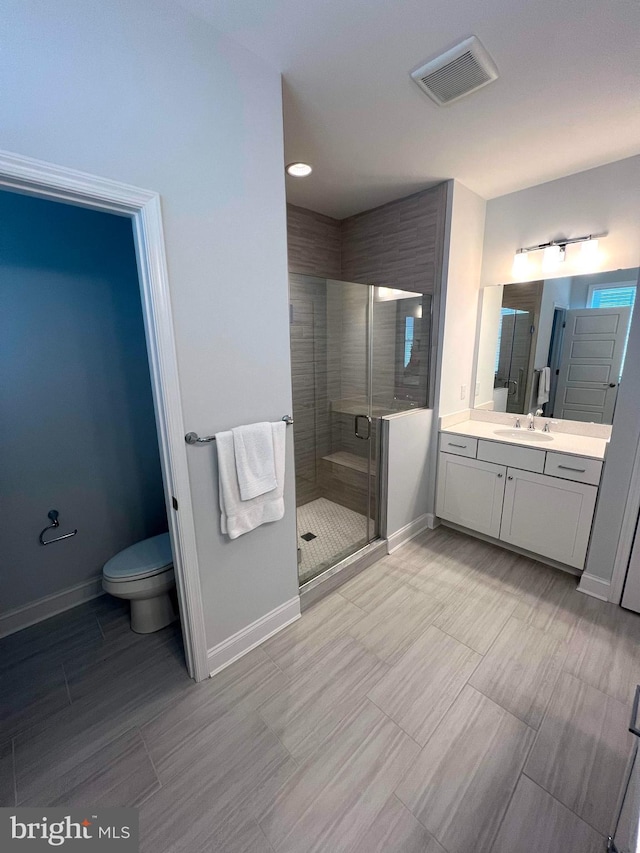 bathroom featuring vanity, an enclosed shower, and toilet